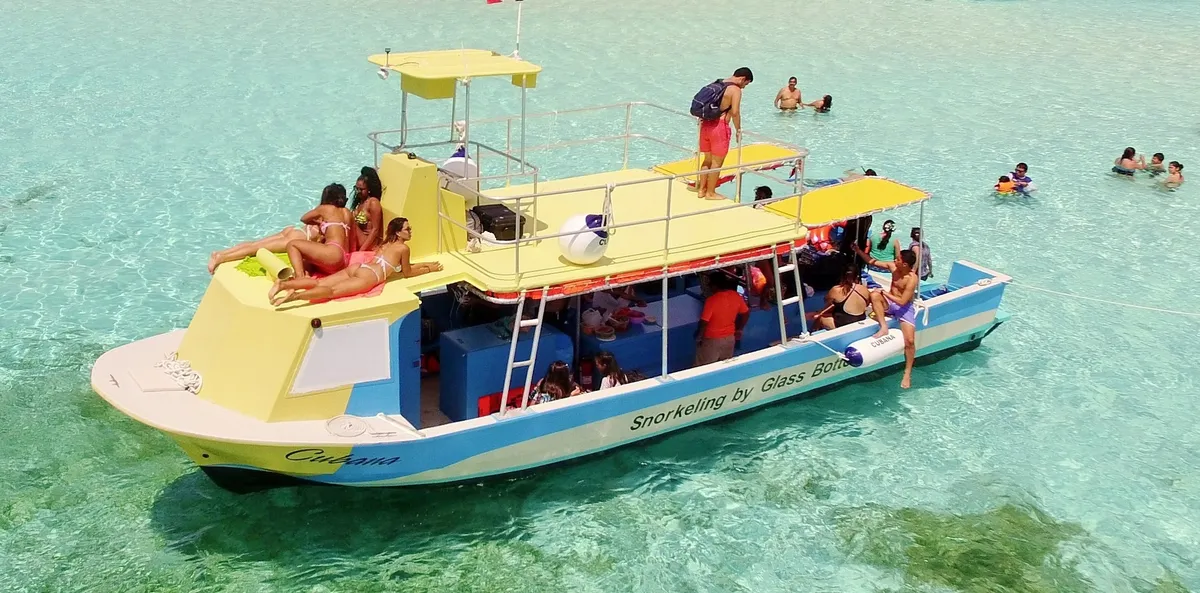 Glass-bottom boat anchored over a shallow reef on a Cozumel boat tour off the leeward coast