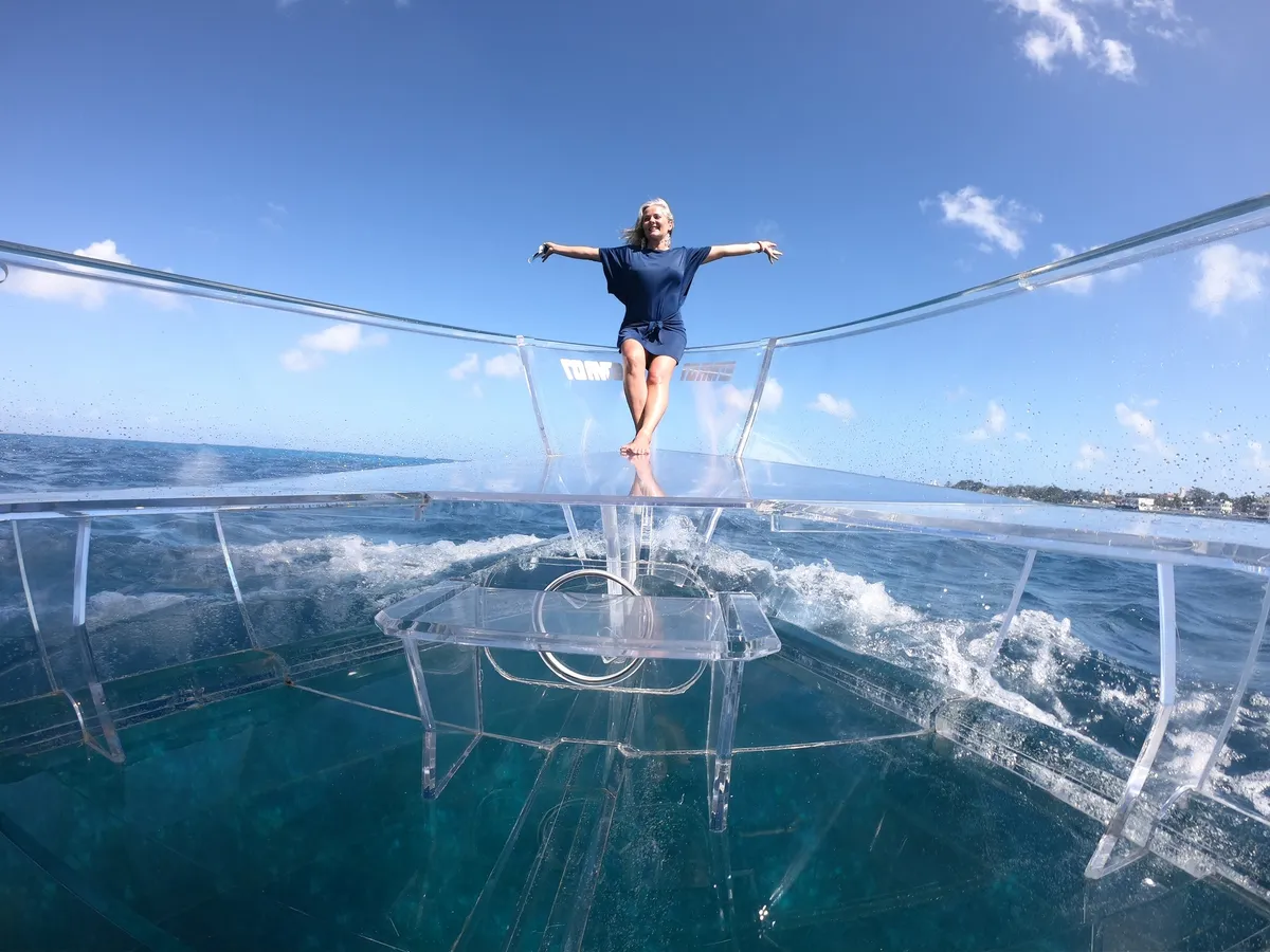 See-through clear boat cruising the calm turquoise coast on a short Cozumel boat tour with snorkeling
